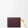 Kompakte Geldbörse mit Knotenverschluss aus glänzendem Nappakalbsleder in Dark Burgundy/Light Citrine